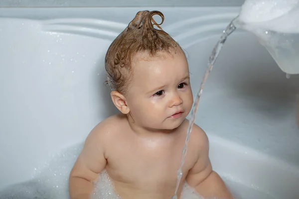 Washing adorable baby in bathroom. Kid with soap suds on hair taking bath. Closeup portrait of smiling kid, health care and kids hygiene. Todler in shower, funny infant in shower. — Stock Photo, Image