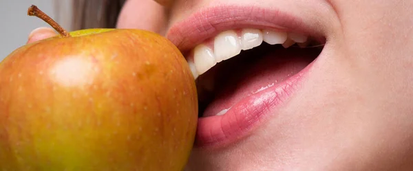 Hermosa joven comiendo manzana roja. Muerde una manzana. Boca de cerca. — Foto de Stock