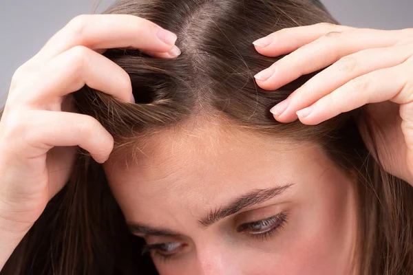 Sad woman with hair loss problem worried about hair loss.