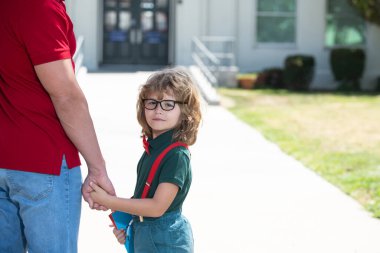 Baba oğlunu destekliyor ve motive ediyor. Çocuk ilkokula gidiyor..