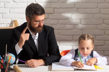 Çocuk eğitimi, ilkokul ve öğrenme konsepti. Konsantre liseli kız ve sınıfta yazan ciddi öğretmen..