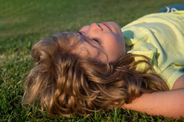 Yaz parkında çimlerin üzerinde oynayan mutlu çocukların portreleri..