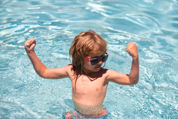 可爱的男孩展示肌肉，在游泳池游泳，夏季水底有复制空间。有趣的孩子们面对. — 图库照片