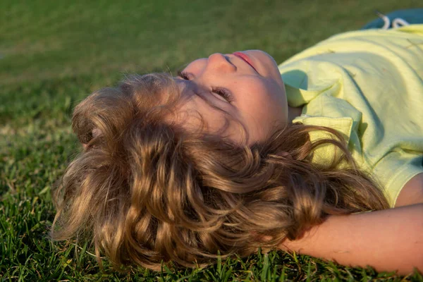 Porträtt av glada barn som leker och lägger på gräs utomhus i sommarparken. — Stockfoto