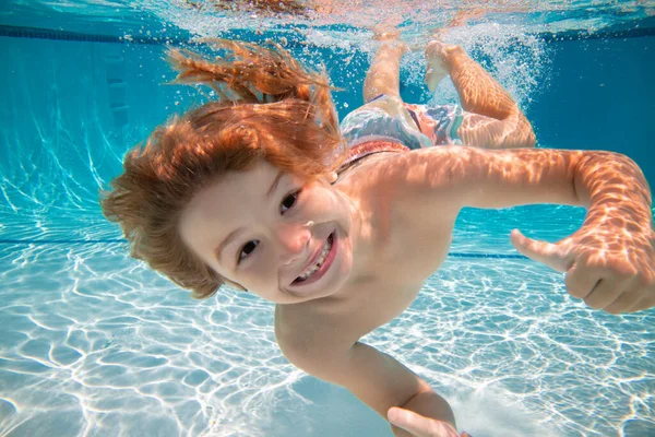 Happy kid boy swim and dive underwater, kid with fun in pool under water. Active healthy lifestyle, water sport activity and swimming lessons on summer vacation with child. — Stockfoto