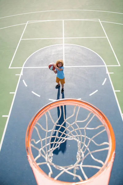 Vista en ángulo desde la parte superior de la identificación del niño jugando baloncesto en el patio de recreo. — Foto de Stock