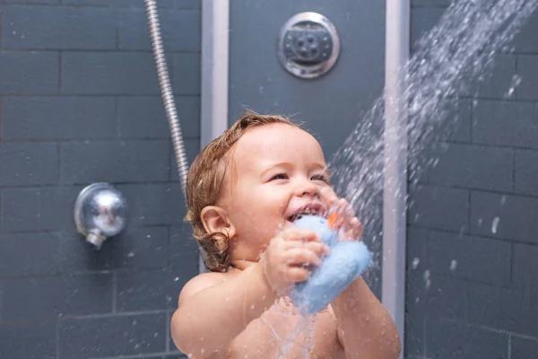 Bébé enfant drôle baigné de mousse et se lavant dans la baignoire à la maison. Joyeux enfant sous la douche. — Photo