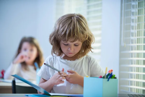 Joli dessin d'écolier en classe. Assez élégant écolier étudiant les mathématiques devoirs pendant les cours en classe, concept d'éducation, Mignon écolier. — Photo