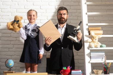 Sınıfta öğretmen olan ilkokul öğrencisi. İlkokulda genç bir kız öğrenciyle öğretmen..