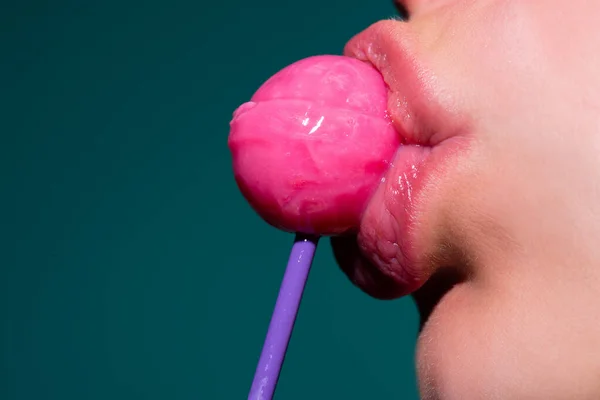 Cukorkát nyalni. Nyalóka modell. A nő szája cukorkát szív. Glamor szexi modell piros ajkak enni izzadság nyalóka pop. — Stock Fotó