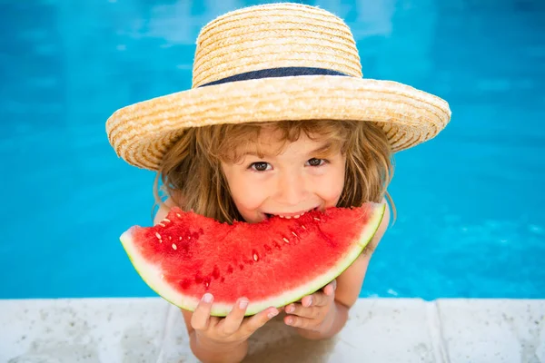 Niño con sandía en piscina al aire libre. Chico divirtiéndose en la piscina. Vacaciones de verano para niños y concepto de alimentación saludable. — Foto de Stock