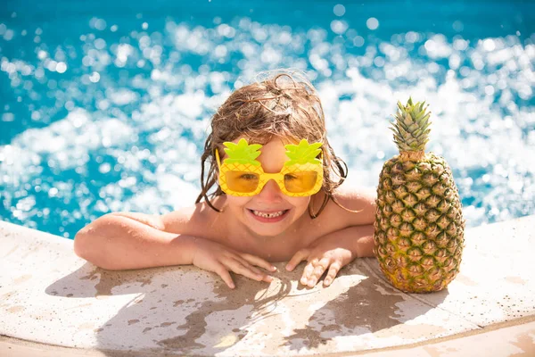 Chlapec dítě šťastný koupání v bazénu. Malé dítě se baví v bazénu. Letní ananas ovoce. — Stock fotografie