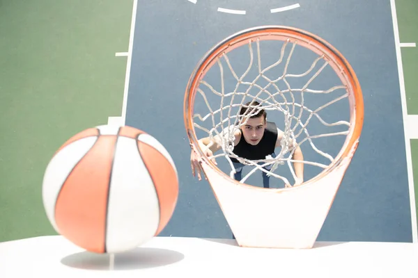 Basketbalspeler. Sport en basketbal. De man springt en gooit een bal in de mand. — Stockfoto