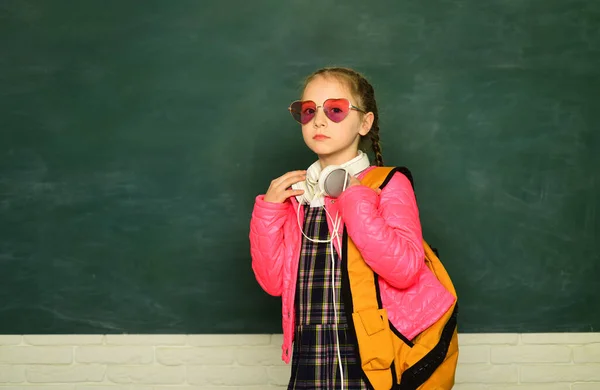 Teenager-Student. Lustiges Schulmädchen mit Brille, Kinderatelier-Porträt. Bildungskonzept. Junge Schülerin mit Schulrucksack und Kopfhörer. — Stockfoto