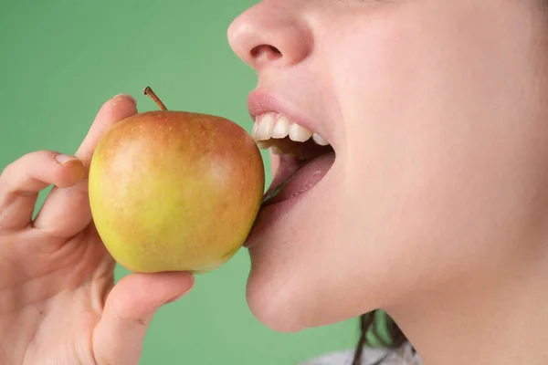 Una hembra mordiendo una manzana. Mujer boca abierta a punto de morder manzana verde. — Foto de Stock