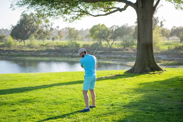 Golfista golpeando tiro de golf con el club en curso. —  Fotos de Stock