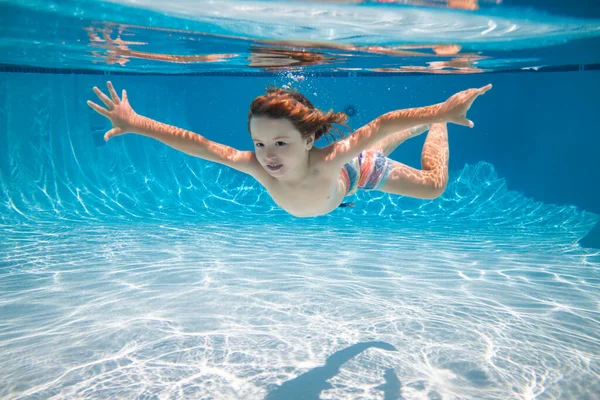 A gyerek a víz alatt úszik a medencében. A kisfiú úszott és búvárkodott a medencében. Nyári családi nyaralás gyerekekkel. Vízalatti gyerekek aktivitása. — Stock Fotó