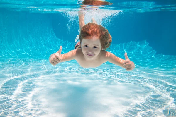 孩子们竖起大拇指在水下游泳.水底小孩在水下游泳.小男孩在游泳池里游泳和潜水。带孩子的夏季家庭暑假。水下儿童活动. — 图库照片