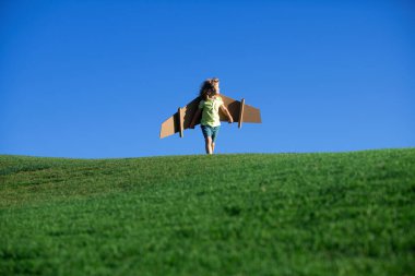 Mavi gökyüzüne karşı oyuncak kanatları olan bir pilot gibi. Çocukların özgürlük kavramı. Açılış.