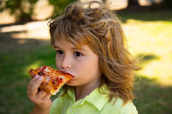 Pizza yiyen çocuk. Çocuk zevki ve bir ısırık pizza. — Stok fotoğraf