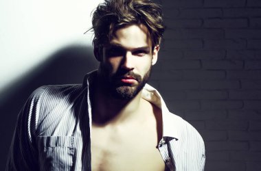 Yakışıklı, kaslı, maço vücut geliştirici, düğmesiz tişörtlü, kaslı.