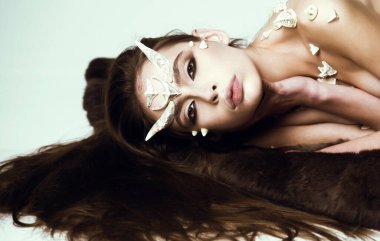 Boynuzları ve dikenleri olan bir şeytan. Cadılar Bayramı hayali yaratığı. Büyülü, korkunç dişi yaratık rahatlamış ışık arka planında uzanıyordu. Kadınlar cadılar bayramı kutlaması gibi barışır.