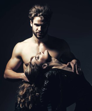 Gövdesi kaslı bir adam kadını uzun saçlarıyla tutuyor.