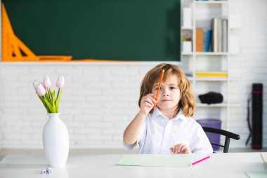 Birinci sınıf. Okulda okuyan bir çocuk. Okul çocuğu sınıfta ödev yapıyor. Çocuklar için eğitim.