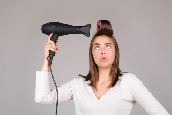 Mujer con secador de pelo. Chica divertida con cabello liso secado cabello con secador de pelo profesional. Peinado, concepto de peluquería. — Foto de Stock