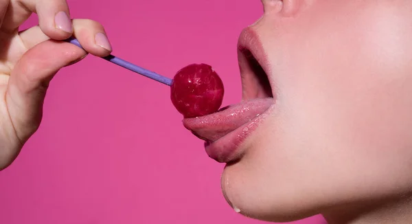 舔嘴唇。性感女人的嘴，粉色的唇托着棒棒糖，美容美发。性感女孩吸舔棒棒糖。美丽动人的概念，特写. — 图库照片