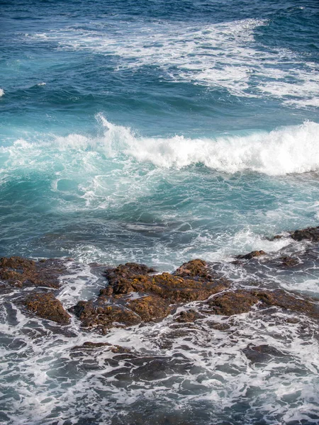 Spetterende golven op de rots in de zee. Wave raakte de steen in de oceaan met een waterbuis achtergrond. — Stockfoto