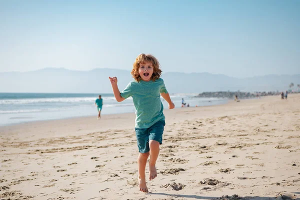 Kid boy correndo e pulando na praia de areia de verão. — Fotografia de Stock