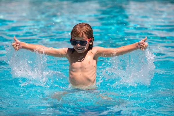 夏天的时候，戴着太阳镜的孩子在游泳池里兴奋极了。在夏天的游泳池里，孩子们举起双手，在水里泼洒着快乐的休闲活动. — 图库照片
