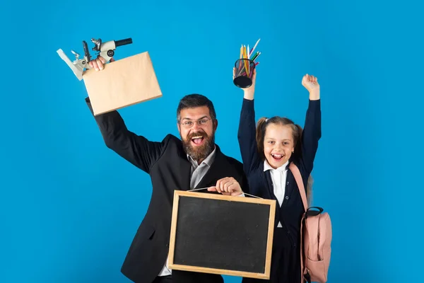 Tutor com menina da escola com acabamento de exercício bem sucedido. Engraçado colegial em uniforme escolar se divertindo no estúdio. Retrato de impressionado animado menina da escola pupila feliz e professor tutor. — Fotografia de Stock