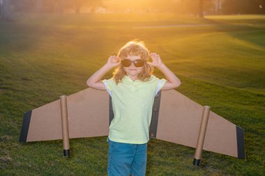 Karton kanatlı çocuk hayal gücü pilot olmayı hayal eder. Yaratıcı ve yenilikçi kavram. Başarı çocuklar ve lider konsepti.