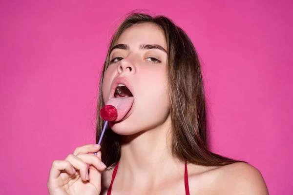 Verleidingsvrouw likt lolly, kunstvaandel, rode lippen met lolly. Sexy rode vrouwelijke mond en tong met lolli pop. Kunstprint voor design. — Stockfoto
