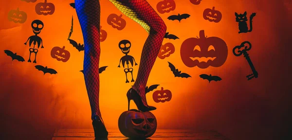 Feiertag-Halloween mit lustigen Karnevalskostümen auf einem Halloween-Hintergrund. Hintergrund für Halloween dekoriert. Sexy junge Frau mit Hexenhut. — Stockfoto