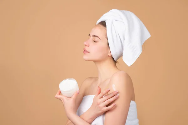 Retrato de cara de belleza. Terapia de spa, hermosa mujer en toalla con productos cosméticos. —  Fotos de Stock
