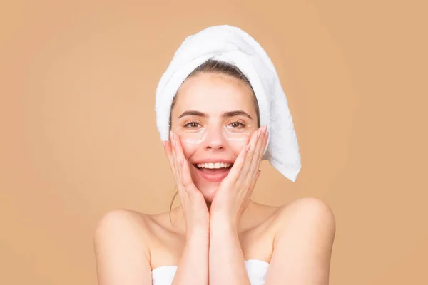 Feliz chica hermosa con una toalla en la cabeza, tratamiento facial, cosmetología, belleza y spa. —  Fotos de Stock