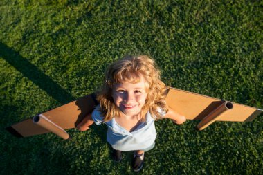 Çocuk hayal gücü parktaki yeşil çimlerde pilot olmayı hayal eder. Yaratıcı ve yenilikçi kavram. Başarı çocuklar ve lider konsepti.