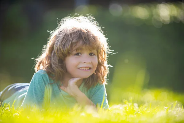 Kind in het zomer natuurpark. Kinderen liggen in grasveld. — Stockfoto