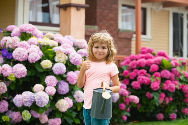 Cute little child boy watering flowers with watering can. — Stock Photo, Image