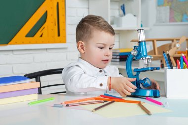 Çocuk sınıfta tahtayla ilgili bir şeyler öğreniyor. Okul çocukları. Ev uzaklığı öğrenimi.