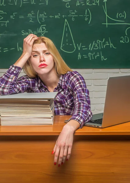 Negatieve gezichtsuitdrukking. Moe van thuis leren. Jonge student op hard examen voorbereiding in de studiezaal ziet er moe en moe. — Stockfoto