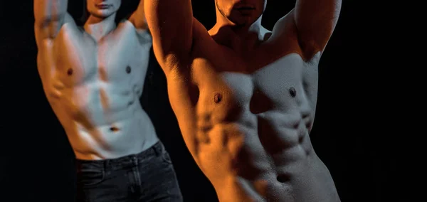 Twee knappe mannen die naakt poseren op een zwarte studio achtergrond. Man die zijn spieren buigt. Sport training concept. Sexy jongens. — Stockfoto