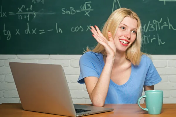 Gelukkige student. Vrouw werkt op laptop computer over schoolbord achtergrond. Jonge vrouwelijke student klaar om examen testen schrijven. — Stockfoto