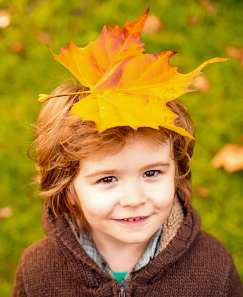 Ευτυχισμένο παιδί που γελάει και παίζει φύλλα σε εξωτερικούς χώρους το φθινόπωρο. — Φωτογραφία Αρχείου