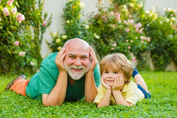 Família feliz O neto abraça o avô de férias. Avô e neto brincando - Tempo de família juntos. Família feliz pai e criança no prado com uma pipa no verão na grama verde. — Fotografia de Stock