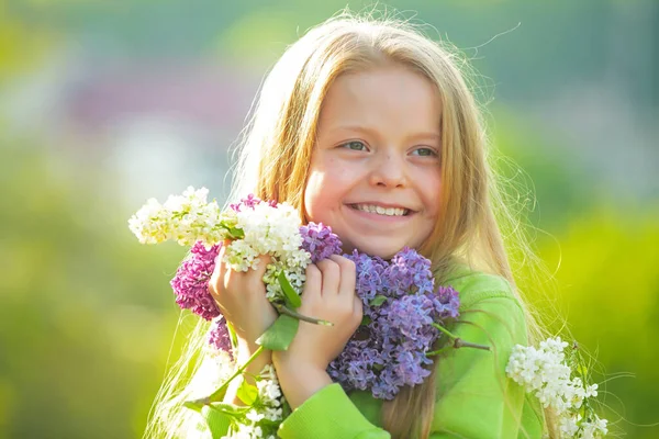 Bahar bahçesinde genç bir bahar kızı. Genç bayan kendini mutlu hissediyor. Komik genç kızın yüz portresi. Leylak buketli kız. — Stok fotoğraf