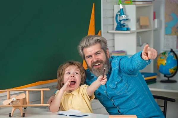 Processo educativo. Giovane padre di famiglia felice e figlio che studia matematica insieme. Studente elementare. Insegnamento individuale. Agenzia di tutoraggio. — Foto Stock